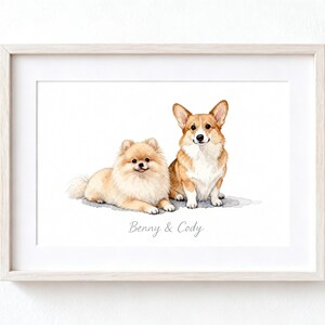 May include: A framed watercolor print featuring a fluffy tan Pomeranian lying down next to a seated tan and white Corgi. The text Benny & Cody is printed in a light gray script font centered below the two dogs on a white background.