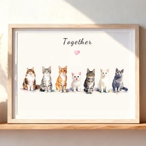 May include: A framed watercolor print featuring seven cats sitting in a row with the word Together written above them and a small pink heart icon below the text. The cats include a long-haired tabby, a grey tabby, an orange tabby, a white cat, a dark tabby, a white cat, and a grey cat.