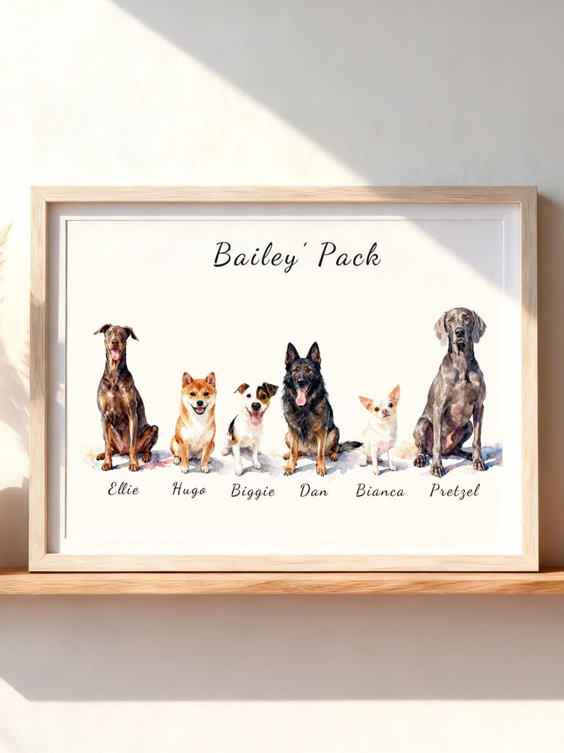 May include: A framed watercolor print titled Bailey' Pack featuring six dogs sitting in a row. The dogs are labeled with the names Ellie, Hugo, Biggie, Dan, Bianca, and Pretzel. The artwork is displayed in a light wood frame on a shelf.