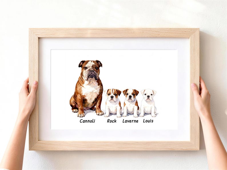May include: A light wood frame containing a watercolor illustration of one adult brown and white bulldog and three smaller bulldog puppies. The names Cannoli, Rock, Laverne, and Louis are printed in black text beneath each respective dog illustration.