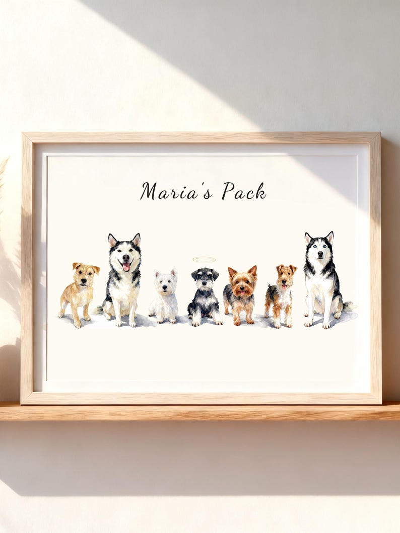 May include: A framed watercolor print featuring seven dogs of various breeds standing in a row. Above the dogs, the text Maria's Pack is written in black script. One dog in the center has a small halo above its head. The frame is light wood.
