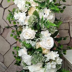 May include: A vertical floral arrangement with white roses, peonies, and greenery. The artificial flowers are densely packed, creating a cascading effect. Ideal for weddings or home decoration, the arrangement is approximately 60 cm in length.