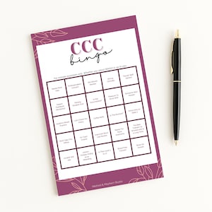 May include: A purple and white CCC Bingo game card with a black pen. The card has a grid of squares with phrases like "Needs More Data" and "Strong Clinicity". The pen is black with gold accents.