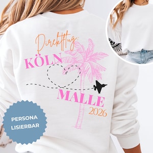Könnte beinhalten: Ein weißes Langarm-Sweatshirt mit einem Rückendruck, der den orangefarbenen Text "Direktflug:", den pinken Text "KÖLN" und "MALLE" sowie das orangefarbene Jahr "2026" zeigt. Das Design umfasst eine pinke Palme, ein schwarzes Flugzeug und eine Herz-Flugroute.
