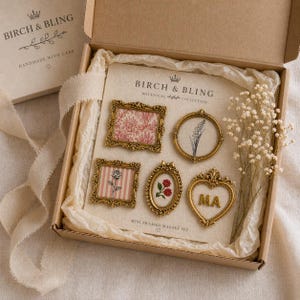 May include: A gift box containing mini framed magnets with gold frames and botanical designs. The magnets include the initials "MA". The box is tan and has the text "BIRCH & BLING" and "HANDMADE WITH CARE".