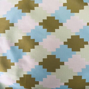 May include: A woven fabric with a geometric pattern in shades of brown, light blue, pink, and green. The pattern is made up of squares and rectangles.