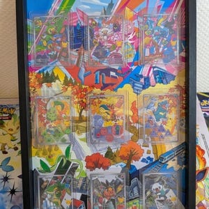May include: A black rectangular shadow box frame containing nine individual trading cards in clear protective sleeves. The cards are arranged in a three-by-three grid over a colorful, multi-paneled background featuring various illustrated characters and cityscapes.