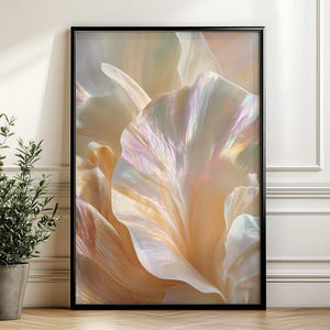May include: A framed art print featuring a close-up of a flower with soft, iridescent petals in shades of cream, peach, and pale pink. The artwork is displayed in a black frame, adding a touch of elegance to the floral design. A potted plant is in the foreground.