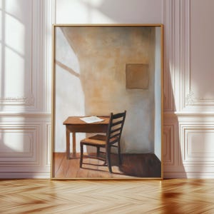 May include: A framed wall art print featuring an oil painting of a wooden desk and a matching chair positioned in the corner of a room. The scene depicts a single white paper resting on the desk surface, with soft light casting shadows.