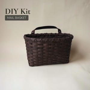 May include: A dark brown woven mail basket with a black handle. The basket is rectangular with a textured surface. The text "DIY Kit" and "MAIL BASKET" are displayed in the upper left corner.