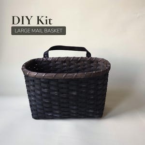 May include: A black woven basket with a brown rim and a black handle. The basket is rectangular with rounded corners. Text above the basket reads "DIY Kit" and "LARGE MAIL BASKET".