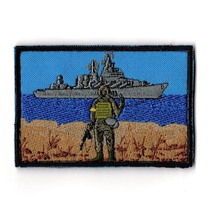 Peut inclure: Écusson brodé représentant un soldat sur une plage, face à un navire de guerre sur la mer. Le fond est bleu, avec une bordure bleue et une bordure noire. Le soldat tient un fusil.