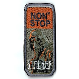 May include: A rectangular embroidered patch with a dark gray border. The top section is orange with the text NON STOP in dark blue. The bottom section is olive green featuring an embroidered figure in a gas mask with the white text STALKER below.