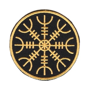 May include: A circular embroidered patch featuring a black background with a gold Vegvisir symbol stitched in the center. The design includes eight radiating arms with distinct markings, all enclosed within a thick gold circular border.