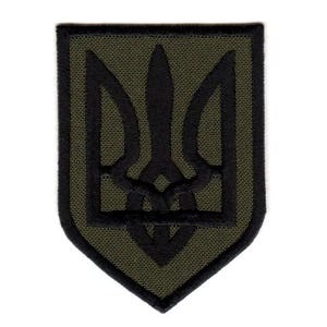 Puede incluir: Parche bordado en verde y negro con el Tryzub, el emblema nacional de Ucrania. El diseño presenta un tridente negro dentro de un borde en forma de escudo. El parche tiene un acabado texturizado.