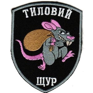 May include: Embroidered patch with a cartoon rat carrying a sack. The rat is grey with pink ears, feet, and tail. The patch has the text "ТИЛОВИЙ" above the rat and "ЩУР" below, all in white letters on a black shield.