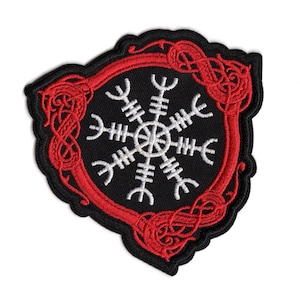 May include: A shield-shaped embroidered patch featuring a black background with a white Vegvisir symbol at the center. The patch is bordered by a red, intricate Celtic-style knotwork frame and finished with a black stitched edge.