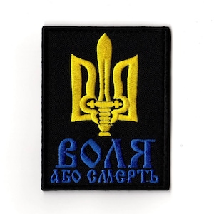 May include: A black embroidered patch featuring a yellow trident emblem and blue Cyrillic text that reads "VOLYA ABO SMERTL". The patch has a rectangular shape and is likely designed to be sewn or ironed onto fabric.