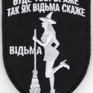 May include: Black patch with white embroidered text and a witch silhouette. The text reads "BUДE TOБI BPAЖE TAK ЯK BIДЬMA CKAXE" and "BIДЬMA". The witch is holding a broom and wearing a hat.