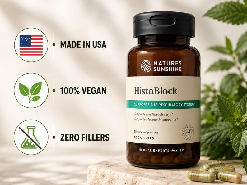 May include: A brown glass bottle of HistaBlock capsules with a black lid, set on a stone surface. The label indicates it supports the respiratory system and is made in the USA, 100% vegan, and contains zero fillers. Green capsules are scattered nearby.