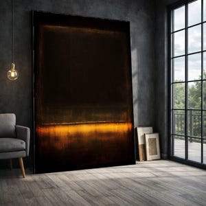 May include: Large abstract painting with a dark brown and black background and a horizontal band of golden yellow near the bottom. The artwork is displayed in a room with a gray armchair, a window, and a hanging light.