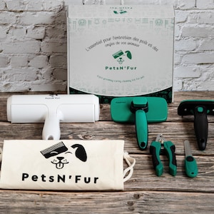 Peut inclure: Un kit de toilettage pour animaux de compagnie avec un rouleau blanc, des brosses vertes, des coupe-ongles et un sac en toile. Le kit comprend une boîte avec du texte en français et en anglais, et la marque "PetsN'Fur".