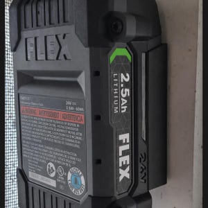 Może przedstawiać: Czarny i szary akumulator litowo-jonowy FLEX 24V 2,5Ah. Akumulator ma zielony akcent i widoczny jest napis "2.5Ah Lithium". Akumulator jest przeznaczony do elektronarzędzi.