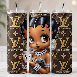May include: A set of three stainless steel tumblers featuring a cartoon image of a woman with black hair, wearing a black dress and jewelry, holding a coffee cup. The tumblers have a brown background with the Louis Vuitton logo and text.