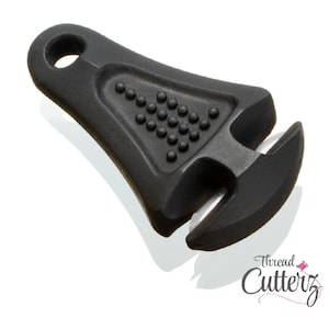 May include: Black thread cutter with a textured grip and a curved blade. The cutter has a hole for attaching to a keychain or lanyard. The Thread Cutterz logo is visible in the bottom right corner.