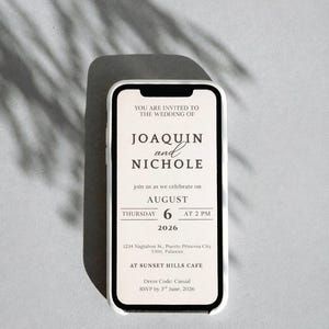 May include: A smartphone displaying a wedding invitation. The invitation is for Joaquin and Nichole, with the date August 6, 2026, at 2 PM. The dress code is casual, and the RSVP date is June 3, 2026.