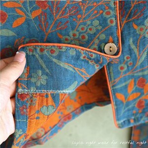 May include: Close-up of a teal pajama top with an orange floral pattern and orange trim. The fabric is quilted and has a button closure. The text "Layla night wear for restful night" is visible at the bottom.