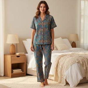 May include: Teal pajama set with a botanical print. The short-sleeved top and pants feature an orange trim. The fabric has a pattern of orange and green leaves. The pajamas are made of a soft, comfortable material.