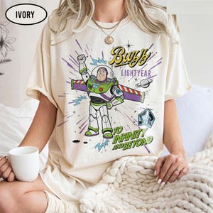 May include: A white ceramic mug with a black handle and the text "But First, Coffee" in a black, handwritten-style font. The mug is on a white surface.