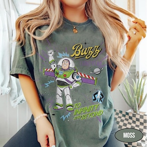 May include: A set of three ceramic mugs with a speckled, matte finish. The mugs are in shades of cream, light gray, and dark gray. Each mug has a simple, minimalist design and a rounded handle. The mugs are likely for coffee or tea.