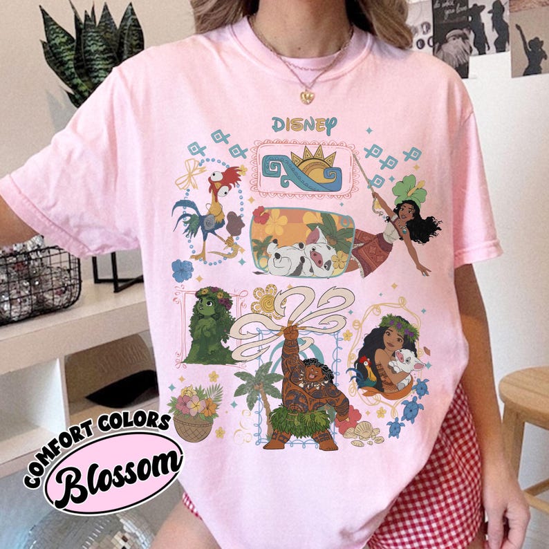 以下が含まれることがあります： ピンク色のComfort Colors Tシャツ。ディズニーのグラフィックで、映画モアナのキャラクターが描かれています。デザインには、ヘイヘイ、プア、ヘイヘイ、モアナ、マウイのイラストが含まれています。「Disney」の文字が上部に印刷されています。