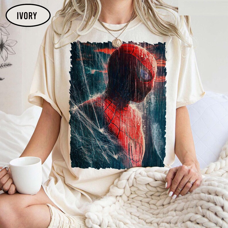 Pu&ograve; includere: T-shirt color avorio con grafica di Spider-Man sotto la pioggia. Il costume rosso e nero del supereroe &egrave; dettagliato, con un focus sulla sua maschera e sugli effetti dell'acqua. La maglietta ha una vestibilit&agrave; ampia.