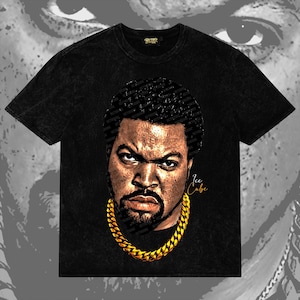 Puede incluir: Camiseta negra con un gráfico de Ice Cube con una cadena de oro. La imagen tiene un aspecto desgastado, con el nombre "Ice Cube" en escritura dorada. La camiseta tiene una etiqueta de la marca Retro.