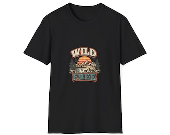 May include: A black short-sleeved t-shirt featuring a graphic print on the chest. The design displays a sunset over mountains, a forest, and deer, with the text WILD in a cream color above and the word FREE in a blue color below the scene.