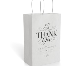 May include: A white paper gift bag with two twisted paper handles. The front features black printed text that reads THANK YOU, followed by smaller text stating for supporting my small business and packed with love just for you, with heart icons.