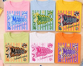 May include: Six t-shirts in pink, light blue, yellow, light green, white, and orange. Each shirt features a graphic of a checkered pennant with the text MASCOT and School name, surrounded by stars, a bow, and a pom-pom illustration.