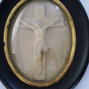 alte kleine Bimssteinschnitzerei von Jesus am Kreuz, in einer gewölbten gießenden, religiösen Plakette