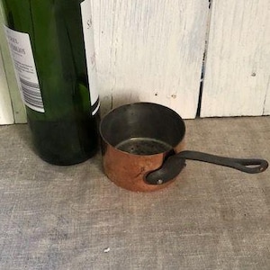 Op de afbeelding: Witte keramische mok met een zwart oor en de tekst "But First, Coffee" in handschrift. Geschikt voor warme dranken, met een glanzende afwerking.