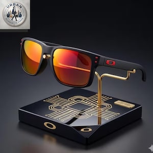 Puede incluir: Gafas de sol negras con lentes reflectantes naranja-rojo y un logotipo rojo en la patilla, montadas sobre un soporte negro con un patrón de circuito dorado y el logotipo de Oakley en el borde frontal, sobre un fondo oscuro.