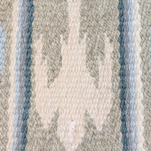 May include: A woven textile featuring a repeating off-white bird motif centered on a sage green background. The design includes vertical stripes in shades of light blue, dark blue, and white, creating a textured pattern across the fabric surface.