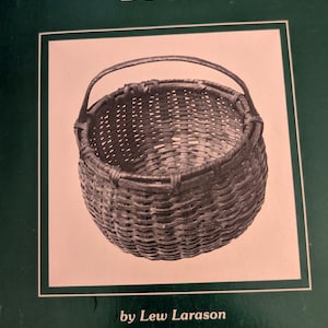 Puede incluir: La portada de "The Basket Collectors Book" presenta una cesta tejida con asa. El título está en escritura blanca, sobre un fondo verde oscuro. El nombre del autor, Lew Larason, está impreso debajo de la imagen.