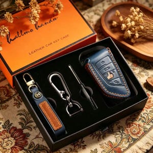 May include: A leather car key case set in a black box with an orange lid. The set includes a blue leather key fob, a keychain, and a screwdriver. The box is labeled "LEATHER CAR KEY CASE".