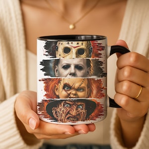 Puede incluir: Una taza de cerámica blanca con asa e interior negros, que presenta un estampado gráfico horizontal de cuatro personajes icónicos de películas de terror apilados verticalmente, incluyendo una máscara de hockey y un rostro con cicatrices.