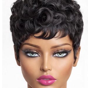 May include: A mannequin head with short, curly black hair. The mannequin has light skin, dramatic eye makeup, and bright pink lipstick. The background is plain white, highlighting the features of the mannequin.