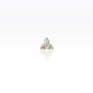 May include: Gold nose stud with three small round clear diamonds arranged in a triangle shape.