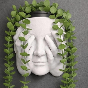 Peut inclure: Une tasse en céramique blanche avec une anse noire et le texte "But First, Coffee" en gras noir. La tasse est posée sur un fond flou, suggérant un cadre chaleureux.